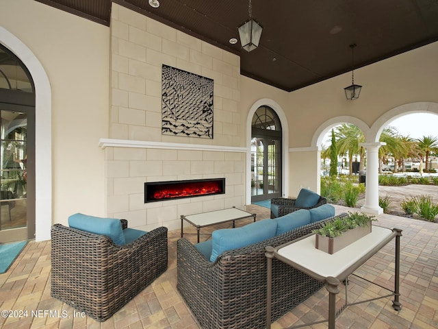 view of patio with an outdoor living space with a fireplace