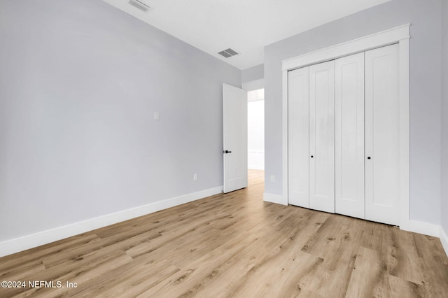 unfurnished bedroom featuring a closet and light wood-type flooring