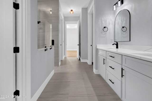 bathroom with a shower with door and vanity