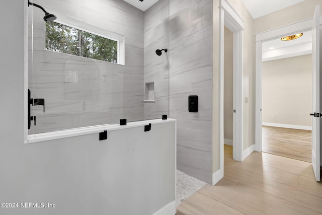 bathroom featuring wood-type flooring and an enclosed shower