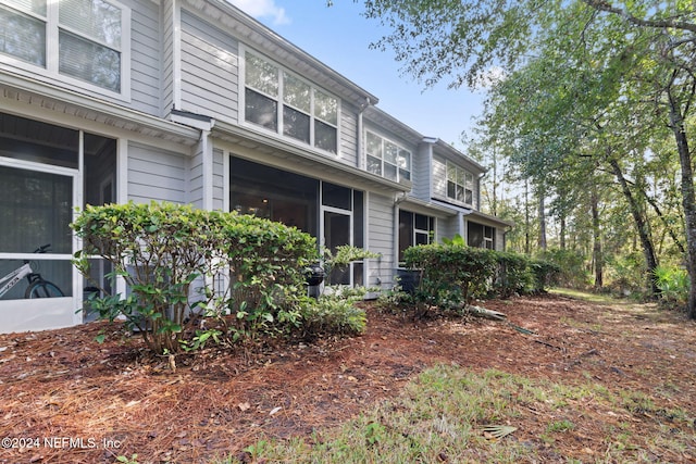 view of property exterior with a sunroom