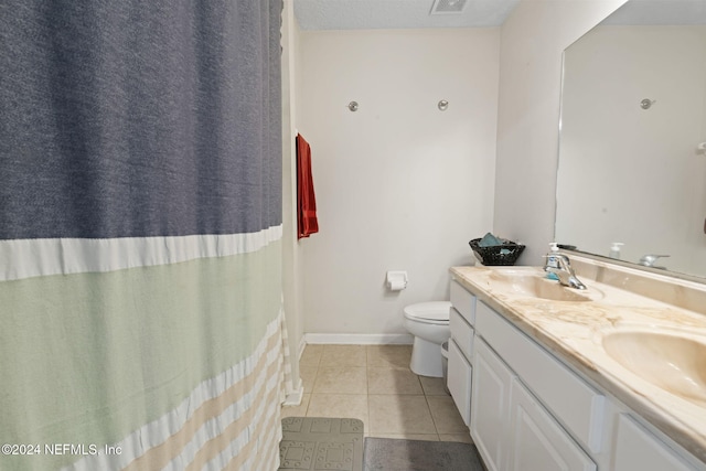 bathroom with tile patterned flooring, vanity, and toilet