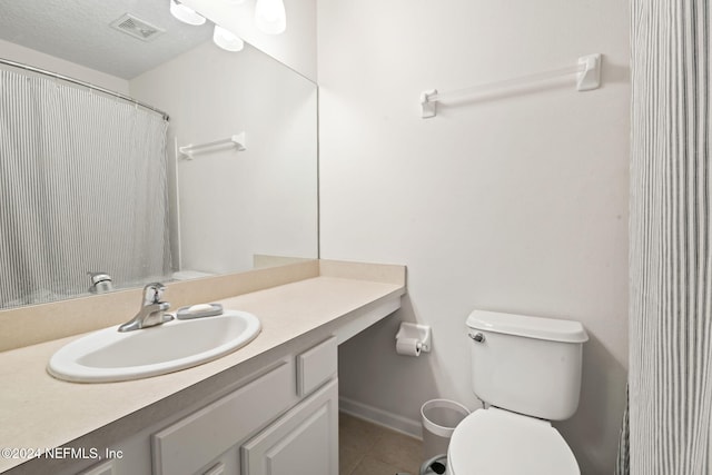 bathroom featuring tile patterned floors, vanity, a textured ceiling, and toilet