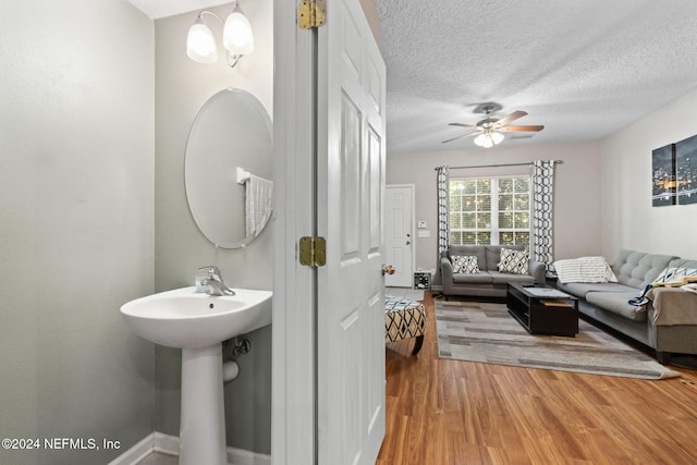 bathroom featuring hardwood / wood-style floors, a textured ceiling, and ceiling fan