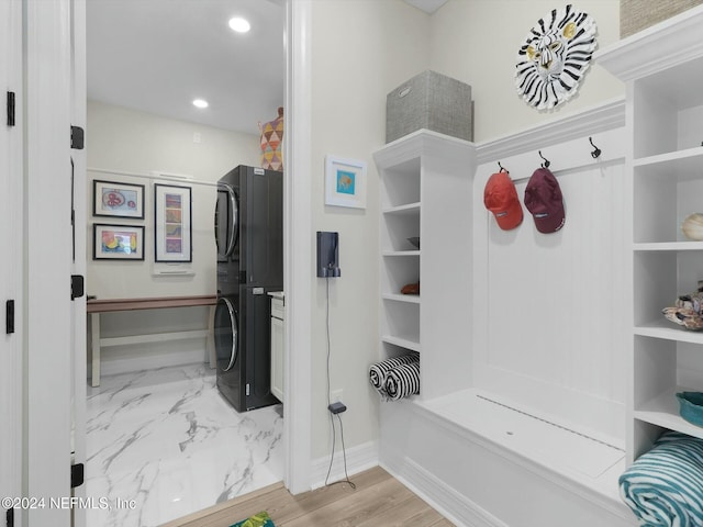 mudroom with stacked washer and clothes dryer