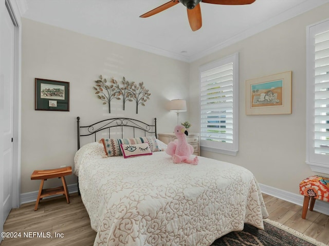 bedroom featuring ceiling fan, a closet, wood-type flooring, and ornamental molding