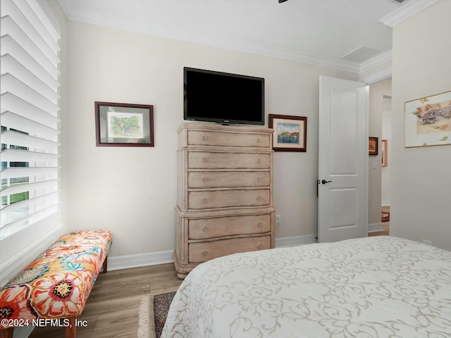 bedroom with wood-type flooring and ornamental molding