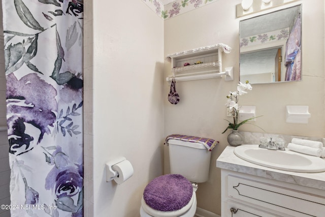 bathroom featuring vanity, toilet, and curtained shower