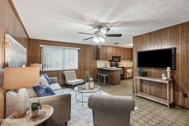 living room featuring wooden walls and ceiling fan