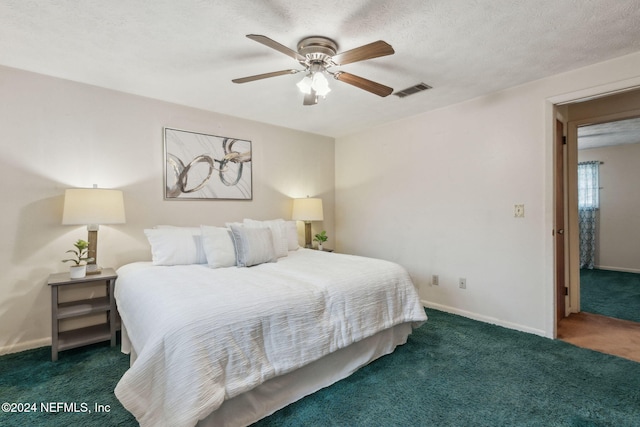 carpeted bedroom with ceiling fan and a textured ceiling