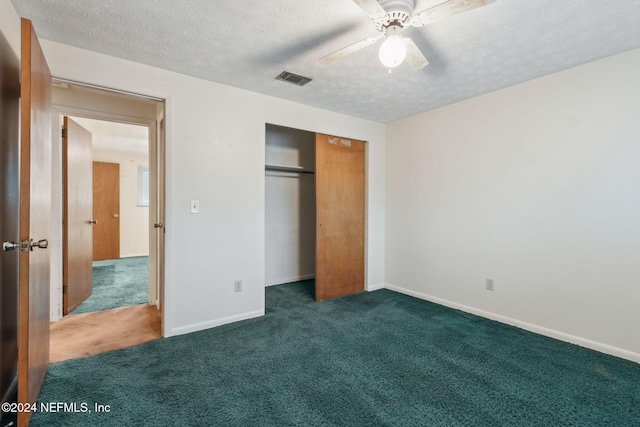 unfurnished bedroom featuring a textured ceiling, a closet, dark carpet, and ceiling fan