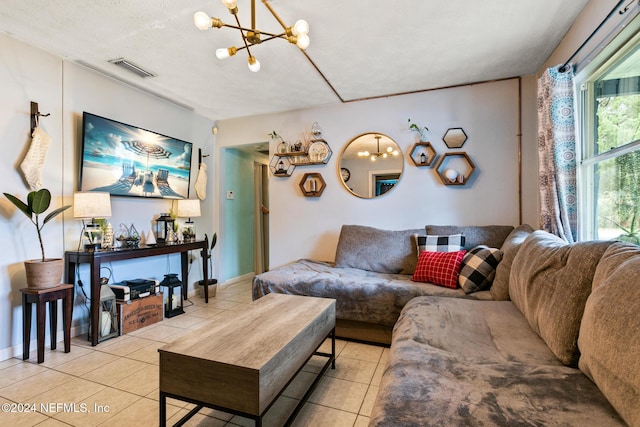 living room with a notable chandelier, light tile patterned floors, and a textured ceiling