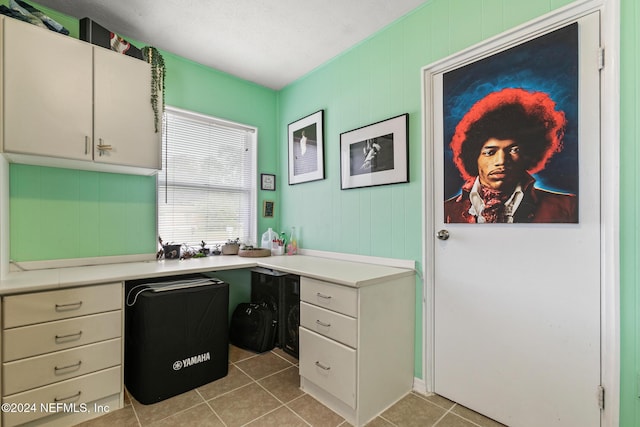 home office with light tile patterned flooring and built in desk