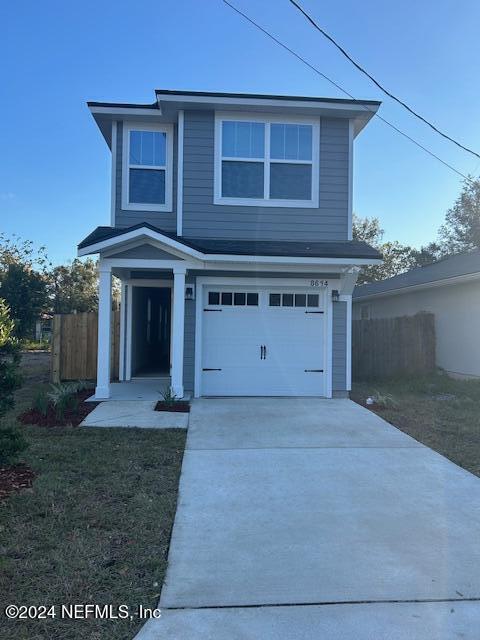 view of front property featuring a garage and a front lawn