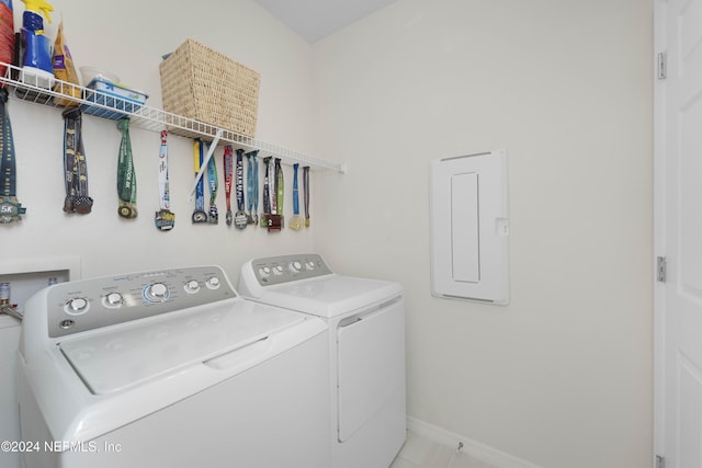 laundry room with independent washer and dryer and light tile patterned floors