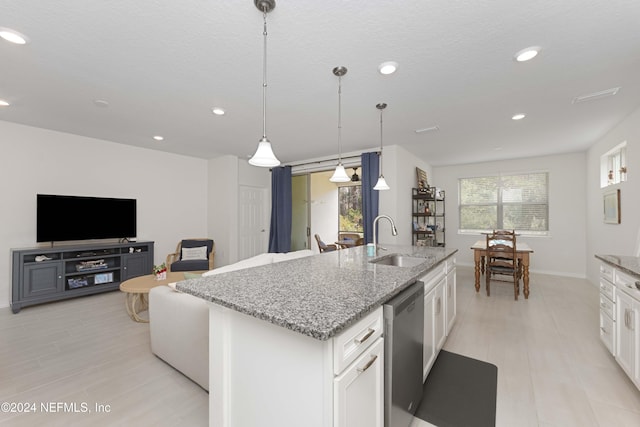 kitchen with a kitchen island with sink, sink, pendant lighting, dishwasher, and white cabinets