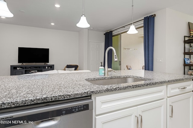 kitchen with sink, stainless steel dishwasher, light stone countertops, decorative light fixtures, and white cabinetry