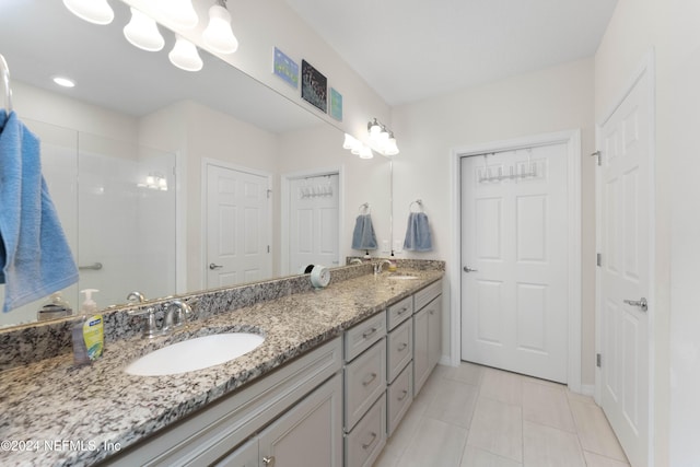 bathroom featuring tile patterned flooring, a shower, and vanity