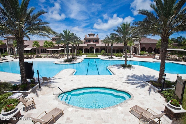 view of swimming pool featuring a community hot tub and a patio