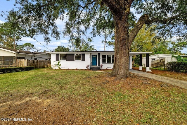 view of front of property featuring a front yard and a carport