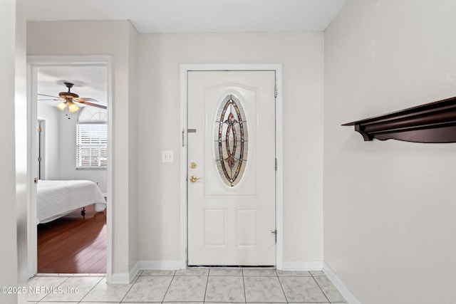 foyer featuring ceiling fan and light tile patterned floors