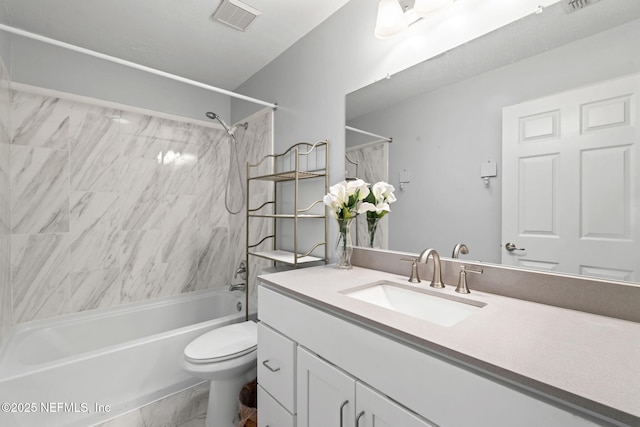 full bathroom with tiled shower / bath, vanity, and toilet