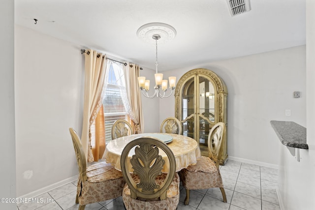 dining room featuring light tile patterned flooring and a chandelier