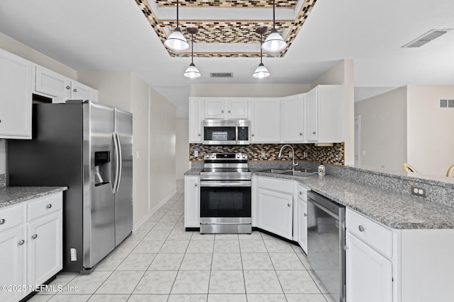 kitchen featuring sink, white cabinetry, hanging light fixtures, and appliances with stainless steel finishes