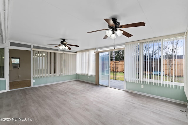 unfurnished sunroom with ceiling fan, cooling unit, and a healthy amount of sunlight