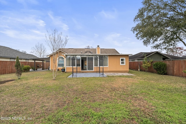 back of property with a lawn and a patio