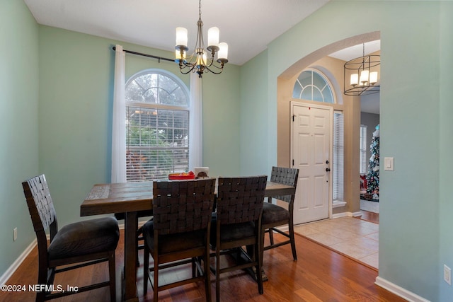 dining space with wood-type flooring and a notable chandelier