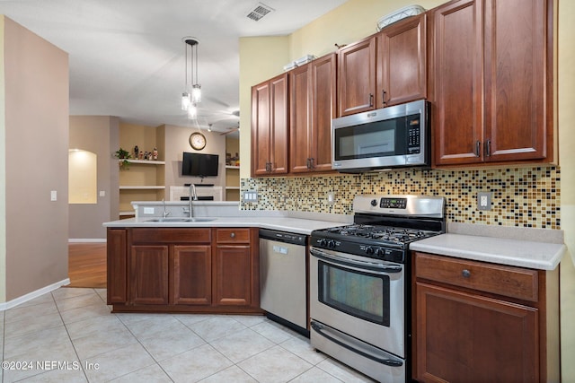 kitchen featuring sink, decorative backsplash, decorative light fixtures, kitchen peninsula, and stainless steel appliances