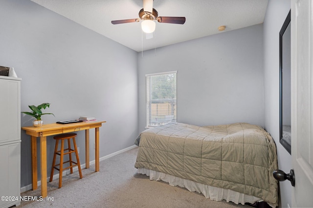 carpeted bedroom with ceiling fan and a textured ceiling