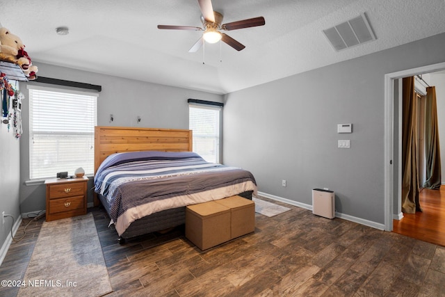 bedroom featuring ceiling fan, dark hardwood / wood-style flooring, and a textured ceiling