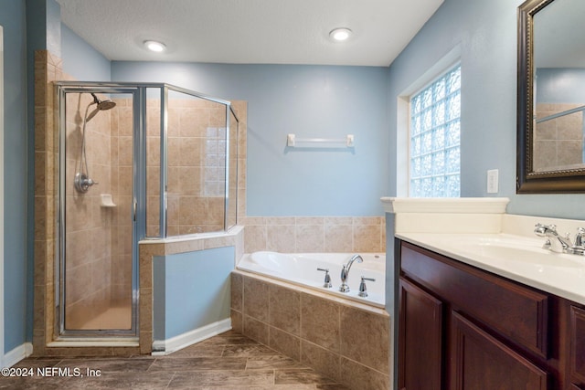 bathroom with vanity, a textured ceiling, and independent shower and bath