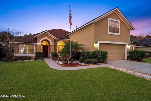 view of front facade with a yard and a garage