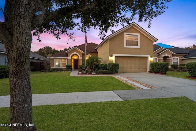 view of property featuring a yard and a garage