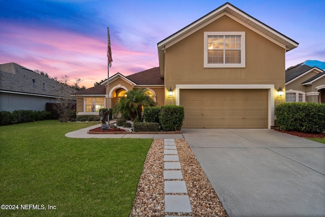 view of property with a lawn and a garage