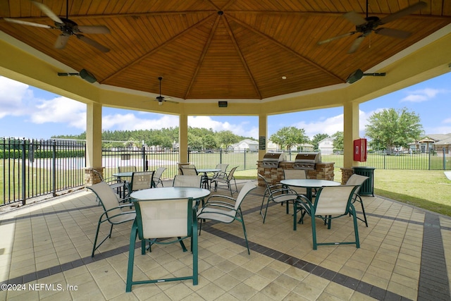 view of patio / terrace with a gazebo, ceiling fan, area for grilling, and a water view