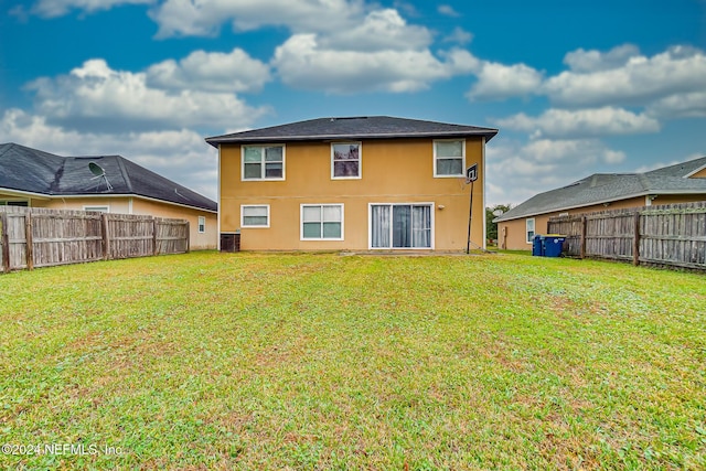 back of property featuring central AC and a yard