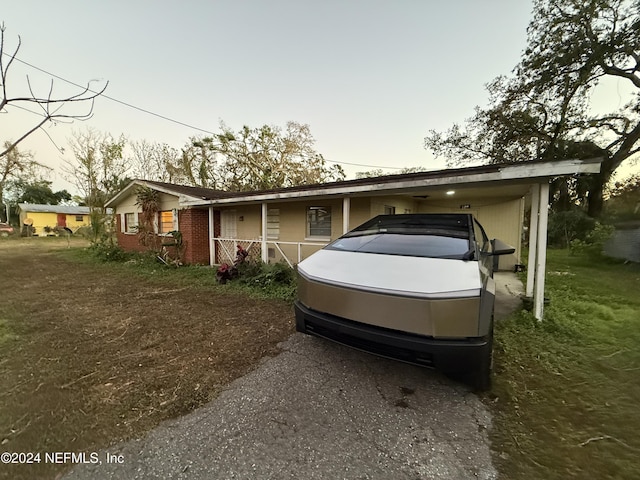 view of front of property featuring a carport, covered porch, and a front yard