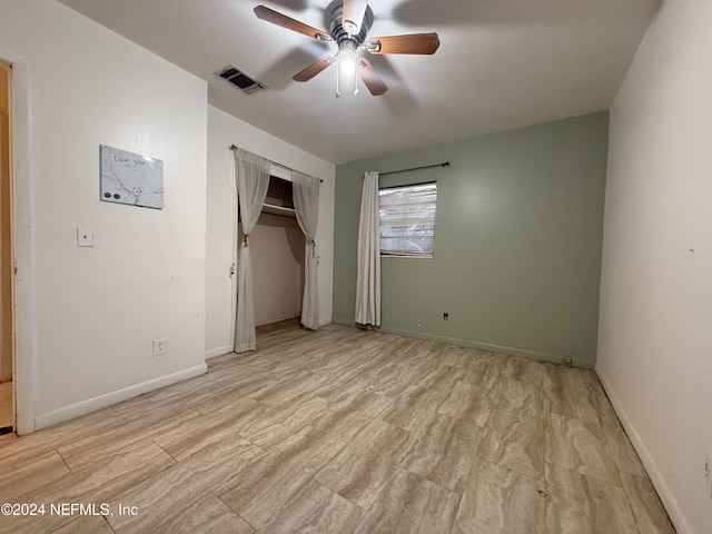 unfurnished bedroom with ceiling fan and a closet