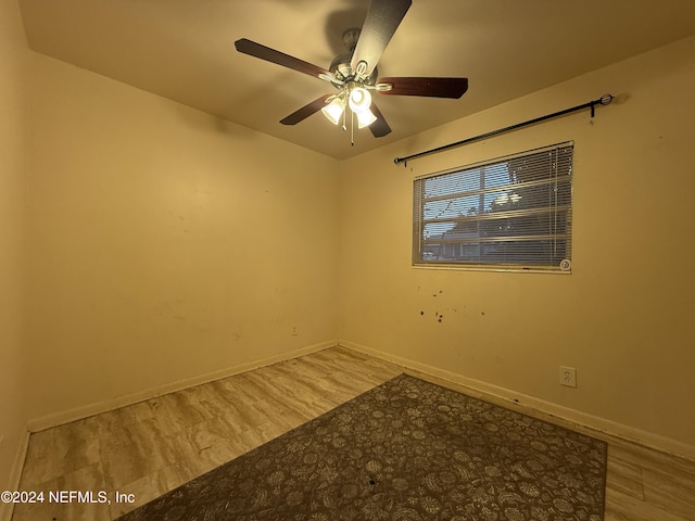 empty room with ceiling fan and light hardwood / wood-style flooring