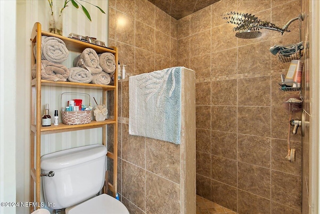 bathroom with tiled shower and toilet