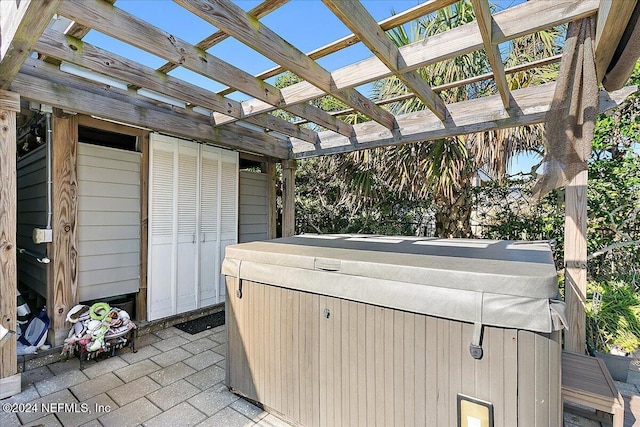 view of patio / terrace featuring a pergola and a hot tub