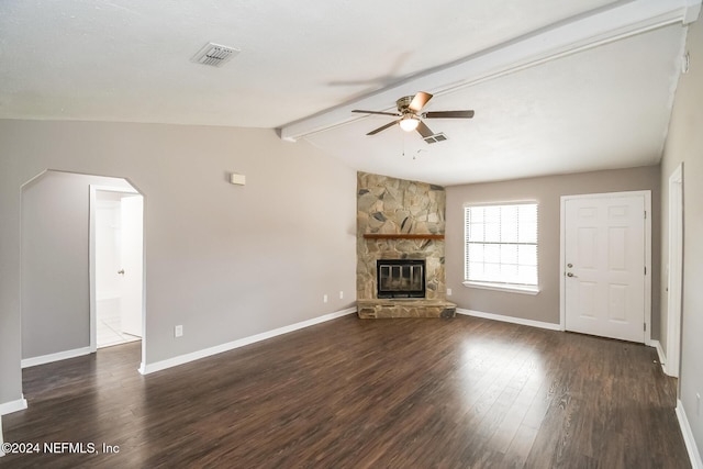 unfurnished living room with vaulted ceiling with beams, ceiling fan, a stone fireplace, and dark wood-type flooring