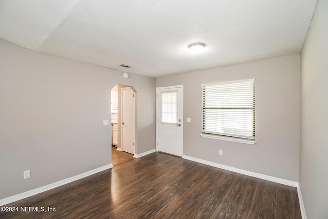 spare room featuring dark wood-type flooring