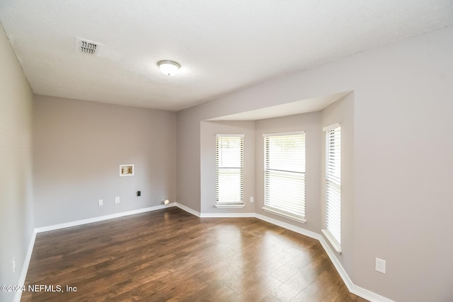 unfurnished room featuring dark hardwood / wood-style flooring and a textured ceiling