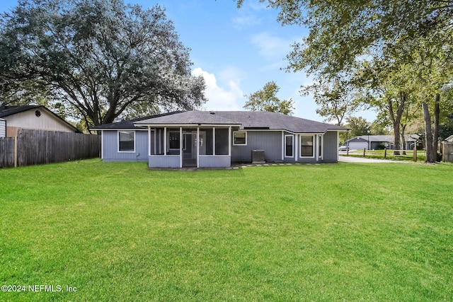 back of house with a yard, central AC, and a sunroom