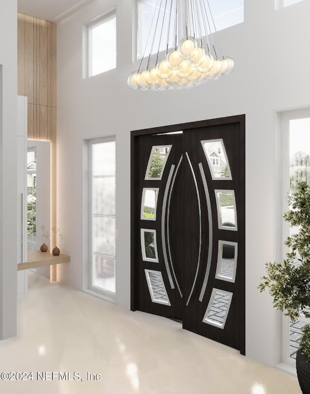 foyer entrance with a towering ceiling and a notable chandelier